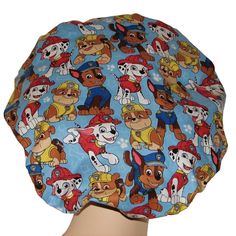 "Scrub Hats Paw Patrol fabric, blue cotton fabric with Marshall, Rubble andChase. None of the hats will be exactly the same as shown in photos due to pattern placement. First impressions matter with patients, put a smile on their face as you roll your patients in and out of the operating room in this scrub hat! Each scrub hat is hand-pleated with a comfortable seamless front band. The back features an elastic band with a cord stop toggle and pony bead to keep the toggle centered. All bouffant sc Marshall Paw Patrol Hat, Veterinarian Scrubs, Bloomsburg Pa, Bouffant Scrub Hat, Operating Room, Leftover Fabric, Scrub Hat, Pony Beads, Scrub Hats