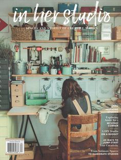 a woman sitting at a desk in front of a bookshelf filled with books