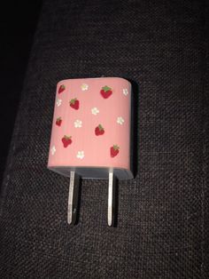 a pink and white square shaped object with strawberries on it