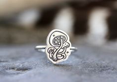 This listing is for one adorable and gorgeously detailed sterling silver magic mushroom ring. The mushroom focal piece is hand stamped onto 18 gauge sterling silver sheet and fired onto sturdy 14 gauge sterling silver wire. Wear this ring solo for simple elegance of wear it stacked with several hammered bands for an edgier, bohemian style! Perfect gift for any nature or woodland lover! It's such a magical ring! - Choose your ring size and stacking options at checkout! - Mushroom focal measures a Whimsical Adjustable Ring Jewelry, Whimsical Adjustable Jewelry Ring, Whimsical Adjustable Ring, Adjustable Whimsical Ring, Nature-inspired Silver Hand Stamped Jewelry, Silver Whimsical Rings For Gifts, Whimsical Silver Rings For Gifts, Whimsical Silver Rings For Gift, Whimsical Sterling Silver Rings For Gifts