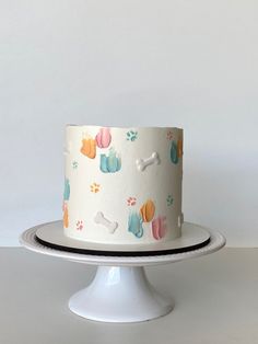 a white cake with colorful dog paw prints on it