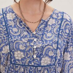 Embrace bohemian charm and effortless style with the Jasmine Blue Bohemian Tunic. Crafted from 100% viscose, this tunic offers both comfort and breathability, perfect for all-day wear. The vibrant blue pattern adds a lively touch to your look, making it a standout piece in your wardrobe. The 3/4 sleeves provide a relaxed yet polished look, while the inner lace detail on the placket adds a touch of femininity and elegance. Featuring a half placket adorned with shell buttons, this tunic exudes und Bohemian V-neck Tunic With Floral Print, Bohemian V-neck Rayon Peasant Top, Blue Relaxed Fit V-neck Tunic, Blue Bohemian Printed Peasant Top, Blue Bohemian Tops With Paisley Print, Bohemian Blue Tops With Paisley Print, Blue Paisley Print Bohemian Tops, Bohemian Blue Paisley Print Tops, Bohemian Rayon Blouse With Boho Print