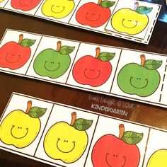 four apples and two oranges are on the table with matching cards to match them