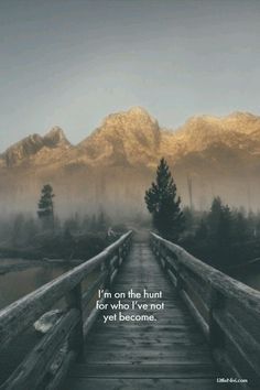 a wooden bridge with mountains in the background and a quote on it that says,