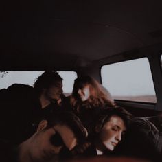 group of people sitting in the back seat of a car