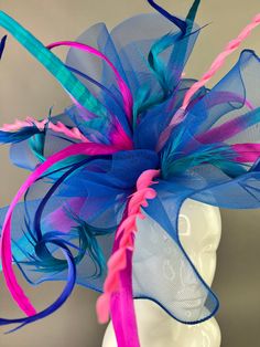 Royal blue crinoline base adorned with ombré pheasant Feathers with a spray of coordinating shades of pink. Attaches with a comfortable, gold headband. Made to wear on the right side of the head. Due to the nature of my items, all sales are final. This fascinator is one size fits all. Looking for a customized piece? Please send me a message and let's create something unique just for you! Don’t forget to follow us on Instagram @TheHatHive Blue Feathered Headband Fascinator, Blue Feathered Fascinator For Spring, Fitted Blue Headpieces With Feathers, Spring Blue Feathered Fascinator, Adjustable Blue Feather Headpiece, Adjustable Blue Feathered Headpiece, Whimsical Blue Fascinator For Party, Crinoline Fascinator, Pheasant Feathers