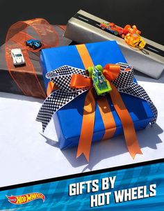 a blue gift box sitting on top of a white table next to a toy car