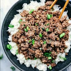 a black bowl filled with rice and ground beef