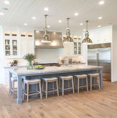 a kitchen island with four stools in front of it and an oven on the other side