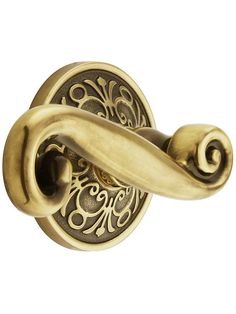 an antique brass door handle with swirl design