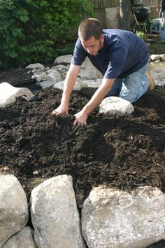 a man is digging in the ground with rocks