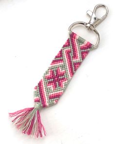 a pink and green beaded keychain with a tassel hanging from it