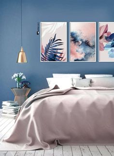 a bedroom with blue walls and paintings on the wall