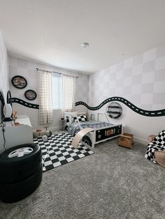 a bedroom with black and white checkered flooring, cars on the wall and a race track painted on the wall