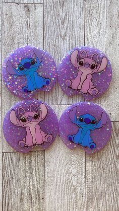 three purple and blue buttons with cartoon characters on them