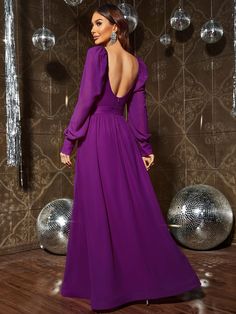 a woman in a long purple dress standing next to disco balls