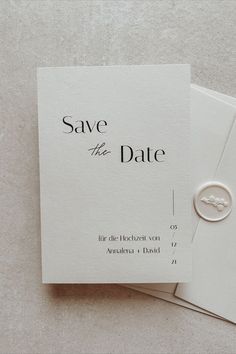 save the date cards on top of each other with a wedding ring in the middle