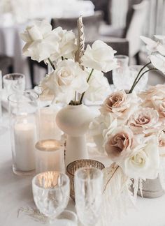 a table topped with lots of white and pink flowers