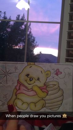 someone is holding up a winnie the pooh card with an image of a teddy bear on it