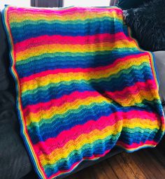 a multicolored crocheted blanket sitting on top of a couch