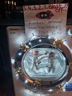 a christmas ornament with two baby dolls in it's reflection on top of a washing machine