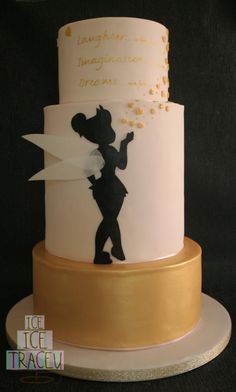 a white and gold cake with a silhouette of a girl holding a star on it