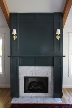 the fireplace is painted dark green and has two lamps on each side, along with an area rug