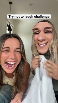 two women are smiling and holding towels in front of their faces, one is laughing at the camera