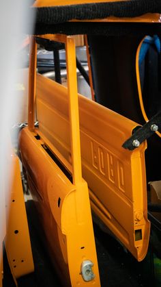 the back end of a yellow school bus with its door open and seat up on it