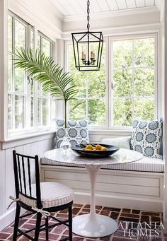 a breakfast nook with two chairs and a bowl of fruit