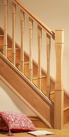 a wooden stair case next to a red pillow