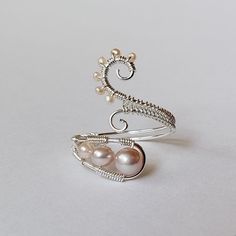 Made to order. Please refer to the shop announcement or the policies page for current production times. Pink pearls and swirls - such a lovely and dainty design. Perfect for spring! The first five pictures are in gold filled, the next two are in rose gold filled, and the last three are in sterling silver. This ring is made to be adjustable. Please suppress the urge to summon the Hulk within - gentle pressure is all that is needed to move the wires that make up the ring form towards or away from Handmade Spiral Rings For Anniversary, Handmade Spiral Anniversary Rings, Handmade Spiral Wedding Ring, Wire Wrapped Jewelry Pendant, Wire Wrapped Stone Jewelry, Wire Wrapped Jewelry Diy, Woven Ring, Ring Wire, Pink Pearls