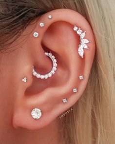 a close up of a person with ear piercings on their ears and behind the ear