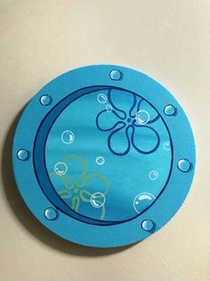 a blue clock with bubbles on it and an octopus in the middle is hanging from a wall