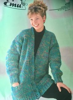 a woman wearing a green sweater and black pants sitting on top of a chair with her hands in her pockets