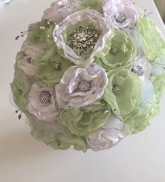 a bridal bouquet with green and white flowers on a dining room table at a wedding