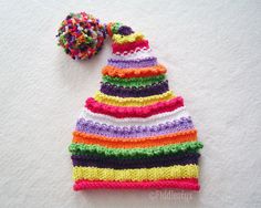 a multicolored knitted hat with a pom - pom on top