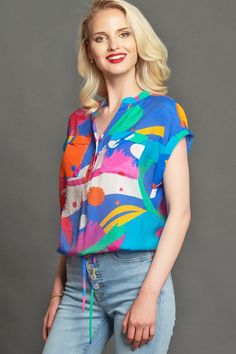 Rolled flutter sleeve woven blouse with functional button placket  and draw string waist closure in Bright multi color print. Fashion; women's fashion; women style; casual style ; tops; casual fashion; fashion ideas; style inspiration, style ideas;  trendy outfits; Fashion for work; summer fashion; spring fashion; trends 2020; #fashion #classyfashion #fashionideas #styleinspiration #styleideas #fashionTrends #fashionInspiration #elegantfashion #fashionstyle #tops #evafranco