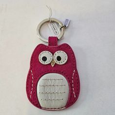 an owl keychain is shown on a white surface