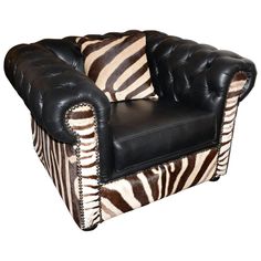 a zebra print chair with black leather upholstered on the armrests and pillows