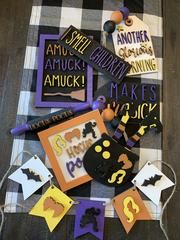 a table topped with lots of different types of halloween decorations on top of a checkered table cloth