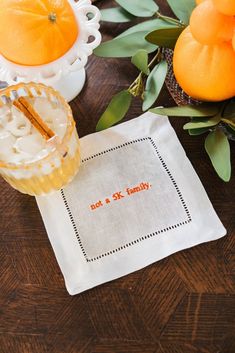 an orange sitting on top of a wooden table next to a cup and saucer