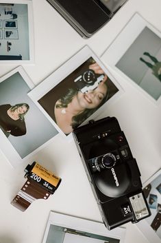 an old camera sitting on top of a table next to pictures and other things around it