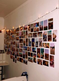 a wall covered in pictures and lights with string lights hanging from the side of it