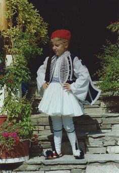 The greek folk costumeTsolias  comes with the cotton pleated kilt (foustanela), the embroidered vest (in blue royal or red crimson color), the cotton long sleeved shirt, the fez, the body stockings, two pairs of small tufts for the decoration of the legs and the waistband, shoes (tsarouchia) are sold separately.  The costume is available in sizes : No 3 for boys 6-8 y.o., No4 for boys  8-11 y.o. and No5  for boys 12-15 y.o. We are a family enterprise and we manufacture these greek traditional co Greek Traditional Clothing, Greek Traditional Dress, Crimson Color, Greek Costume, Ruffle Long Sleeve Dress, Disney Halloween Shirts, Embroidered Vest, European Outfit, Tartan Kilt