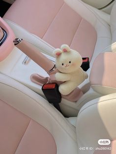 a teddy bear is sitting in the back seat of a car with pink leather upholster