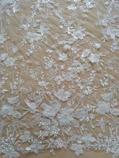 an embroidered lace fabric with white flowers and leaves