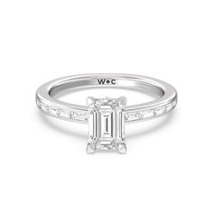 a white gold engagement ring with an emerald cut diamond in the center and side stones