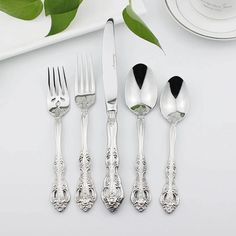 five silverware pieces on a white table