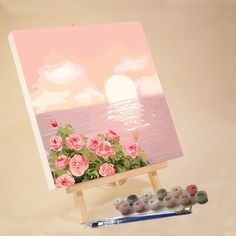 an easel with paint and flowers on it